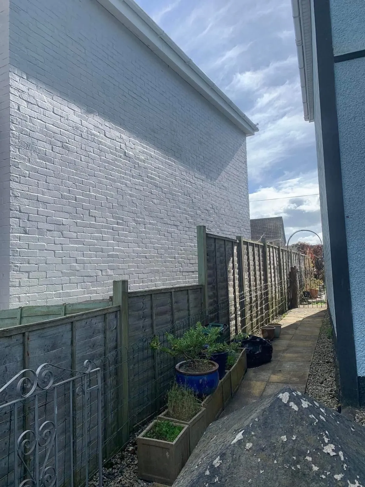Freshly painted brick wall after preparation and masonry paint in Looe